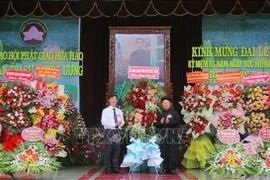 Bui Van Tang (left), Vice President of the Vietnam Fatherland Front Committee of An Giang province, extends congratulations at the grand ceremony marking the 86th founding anniversary of Hoa Hao Buddhism on June 13. (Photo: VNA)