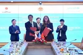 Japanese Ambassador to Vietnam Ito Naoki (first row, left) and UNICEF Representative in Vietnam Silvia Danailov exchange the notes at the ceremony. (Photo: VNA)