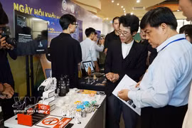 Visitors tour an exhibition showcasing technology and cultural products. (Photo: VNA)