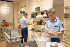 A market surveillance team carries out an unannounced inspection at a fashion business in Hanoi. (Photo: VNA)
