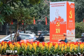 The slogans and emblems of the 14th National Congress of the Communist Party of Vietnam stand out amidst the traffic on the streets of Hanoi. (Photo: VNA)