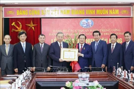 Party General Secretary To Lam presenting the 45-year Party membership badge to Politburo member, Secretary of the Party Central Committee and head of the commission Phan Dinh Trac in Hanoi on August 28. (Photo: VNA)