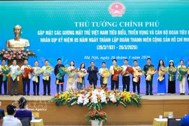Prime Minister Pham Minh Chinh presents flowers to outstanding young people. (Photo: VNA)