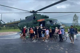 A military helicopter drops relief supplies to a flood-affected area. (Photo: VNA)
