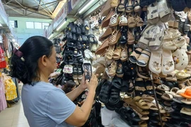 Traders at Dong Da market in Da Nang city use Zalo to sell online. (Photo: VNA)