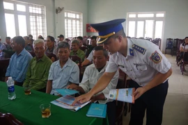 An officer of Coast Guard Region 2 briefs fishermen on IUU fishing prevention at the conference. (Photo: VNA)