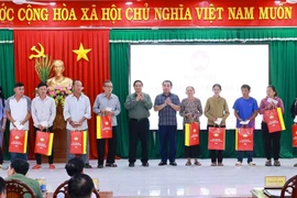 Prime Minister Pham Minh Chinh presents gifts to policy beneficiary families in De Gi commune. (Photo: VNA)