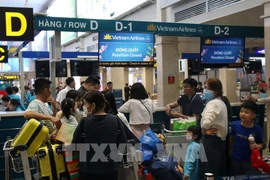 Passengers check in for their flight at Tan Son Nhat Airport. (Photo: VNA)