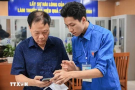 Guiding a local how to apply for administrative procedures on a mobile phone (Photo: VNA)