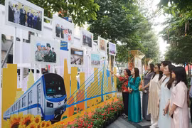 Visitors look at photos at an exhibition which highlights glorious milestones of the Communist Party of Vietnam (Photo: VNA)