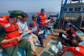 Soldiers from Coast Guard Region 3 and Border Guard provide legal information to fishermen. (Photo: VNA)