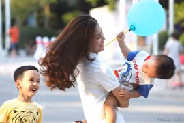 A mother's joy at playing with her children on a weekend. (Photo: VNA)
