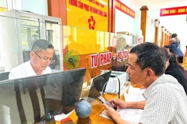 A civil servant processes administrative procedures for local residents at the Public Administrative Service Centre of Dong Trach commune in Quang Tri province. (Photo: VNA)
