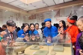 Visitors look at artefacts displayed at the Hanoi Museum. (Photo: VNA)