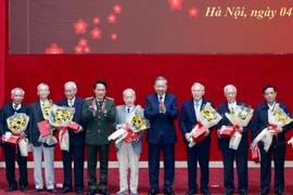 Party General Secretary To Lam (fourth, right) and Minister of Public Security General Luong Tam Quang (fourth, left) present flowers and gifts to former public security officers. (Photo: VNA)