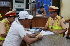 Traffic police in Dong Nai province handle a violation on National Route 14. (Photo: VNA)