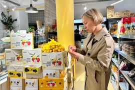 A French customer is tasting Vietnamese lychee. (Photo: VNA)