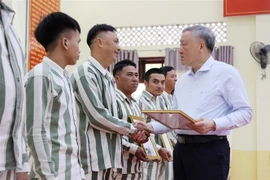 Permanent Deputy Prime Minister Nguyen Hoa Binh presents amnesty certificates to qualified prisoners formerly held at A2 Prison. (Photo: VNA)