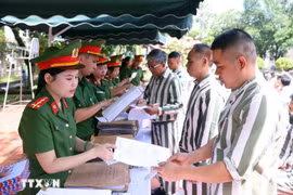 Police officers of the Phu Son 4 Prison present amnesty decisions to persons granted amnesty in 2025. (Photo: VNA)