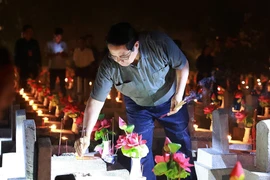 Prime Minister Pham Minh Chinh lights candles and incense to pay tribute to heroic martyrs at Truong Son National Martyrs' Cemetery. (Photo: VNA)