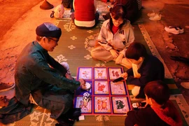 Visitors enjoy a folk game at the event (Photo: VNA)