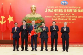 Party General Secretary To Lam (third, left) is awarded the 45-year Party membership badge. (Photo: VNA)
