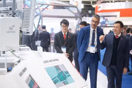 Lieutenant General Cao Duc Thang, Chairman and General Director of Viettel (R) introduces the group's products to a partner at the MWC Barcelona 2026. (Photo: nhandan.vn)