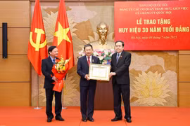 National Assembly Chairman Tran Thanh Man presents a 30-year Party membership badge to Vu Hai Ha, member of the Party Central Committee, Deputy Secretary of the NA Party Committee, Secretary of the Party Committee of advisory and support agencies of the NA Party Committee, and member of the NA Standing Committee, at a ceremony on July 9. (Photo: VNA)