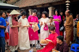 Korean tourists immerse themselves in Dong Ho folk paintings in Duong Lam ancient village, Hanoi (Photo: VNA)