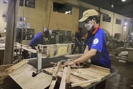 Workers at the Thuan An wood processing factory in Binh Duong province manufacture parts of tables and chairs. (Photo: VNA)