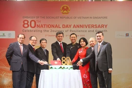 Vietnamese Ambassador to Singapore Tran Phuoc Anh (fourth, right), Singapore's Coordinating Minister for Public Services and Minister for Defence Chan Chun Sing (fifth,right) and Vietnamese Ambassadors who have served in Singapore cut the cake to celebrate the National Day (Photo: VNA)