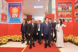 Officials visit the photo exhibition “Under the Party’s Leadership – The nation enters a new era” at the National Convention Centre in Hanoi on January 14. (Photo: VNA)