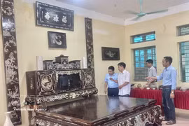 Artisan Vu Van Vinh of Chuyen My village introduces visitors to his family’s mother-of-pearl inlaid lacquerware furniture set, including a platform bed, tea cabinet, lacquered boards and parallel sentences panels, valued at over 3 billion VND (114,000 USD) (Photo: VNA)
