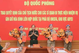 Senior Lieutenant General Phung Si Tan (second from left), Deputy Chief of the General Staff, presents decisions of the State President and the Minister of National Defence to three officers who are about to depart for duties at the UN peacekeeping mission in Abyei. (Photo: VNA)