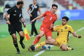 A U22 Malaysia player strives to stop Khuat Van Khang’s dribble. (Photo: VNA)