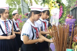 Students offer incense in memory of the 504 innocent civilians killed in the Son My Massacre 58 years ago. (Photo: VNA)
