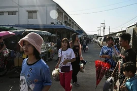 This photo, taken on January 26, 2025, shows Myanmar migrant workers walking to an outdoor market in Thailand's Samut Sakhon province. (Photo: AFP)