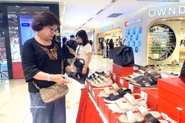 A consumer carefully selects promotional products (Illustrative photo: VNA)