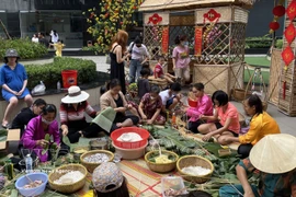 Residents of An Phu apartment complex in Thu Duc, Ho Chi Minh City gather to wrap banh chung in preparation for the Lunar New Year. (Photo: VNA)