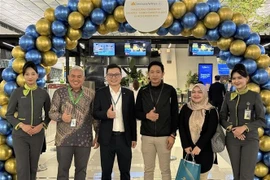 The Vietnam Airlines representative in Indonesia (third from left) in a group photo with passengers of the first flight on the Jakarta-Hanoi route at Soekarno–Hatta International Airport, Indonesia. (Photo: VNA)