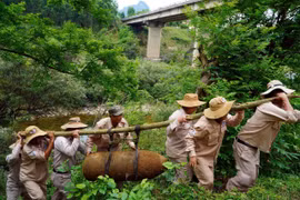 The mobile bomb disposal team from the Mines Advisory Group transports the bomb to a demolition site. (Photo: VNA)
