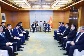 Prime Minister Pham Minh Chinh (right) works with Vice Chairman of COMAC Shen Bo. (Photo: VNA)
