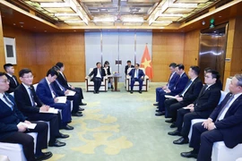 Prime Minister Pham Minh Chinh (right) works with Vice Chairman of COMAC Shen Bo. (Photo: VNA)