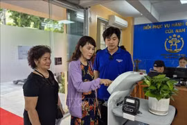 Citizens use AI-powered robot at the Cua Nam ward public service centre. (Photo: VNA)