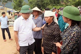 Deputy PM Le Thanh Long offers encouragement to families affected by floods and landslides. (Photo: VNA)
