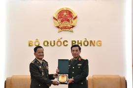 Minister of National Defence Gen. Phan Van Giang (R) hands over a gift to Secretary of State at the Cambodian Ministry of National Defence Gen. Prum Din at their meeting in Hanoi on March 9 (Photo: qdnd.vn)