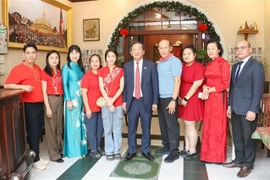 From right: Ambassador Nguyen Minh Tam (5th from right) and the family of Le Dung, former president of the Vietnamese Association in Vientiane. (Photo: VNA)