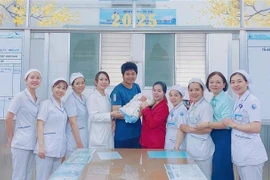 The newborn is discharged from hospital, delighting the family and medical team. (Photo published by VNA)