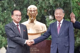 General Secretary of the Communist Party of Vietnam Central Committee To Lam (R) and Jo Yong Won, member of the Presidium of the Political Bureau, Secretary of the Central Committee, and head of the Organisation and Guidance Department of the WPK, shake hands in front of the statue. (Photo: VNA)