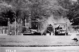 Tank T59 No 390 (left) crashes through the Independence Palace’s main gate at noon of April 30, 1975. (Photo: Francoise de Mulder/VNA broadcasts)